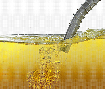 Imagem de uma mangueira de posto dentro de um recipiente com líquido amarelo pode ser álcool ou gasolina